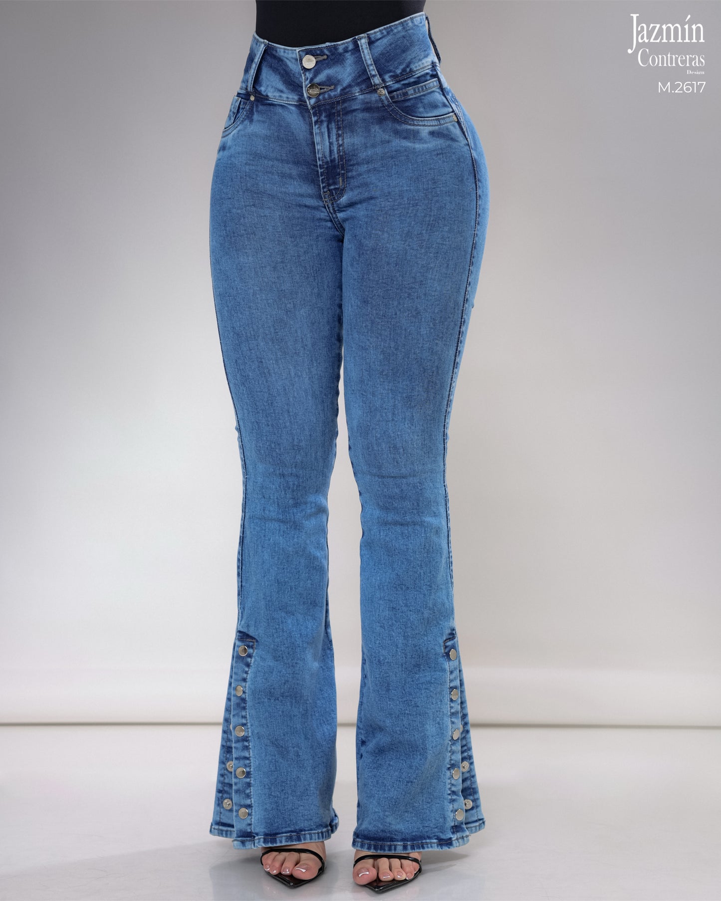 Jeans campana en corte colombiano, con broches metálicos.