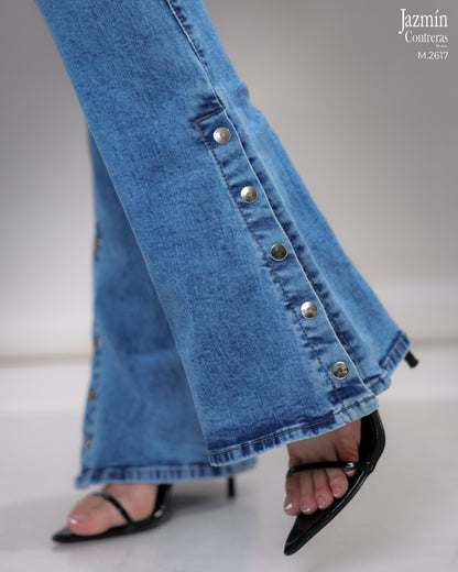 Jeans campana en corte colombiano, con broches metálicos.
